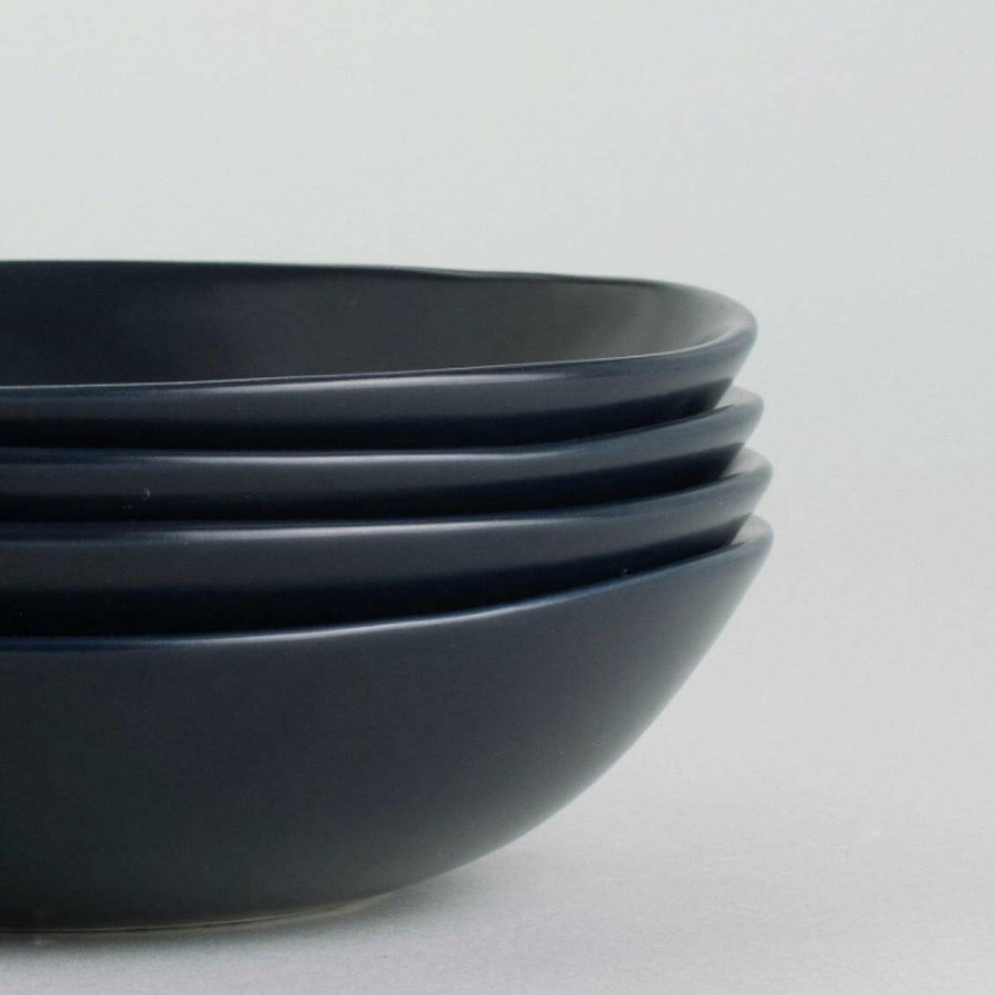 Elegant pasta bowls set on a dining table, showcasing refined craftsmanship and sophisticated design for upscale meals.
